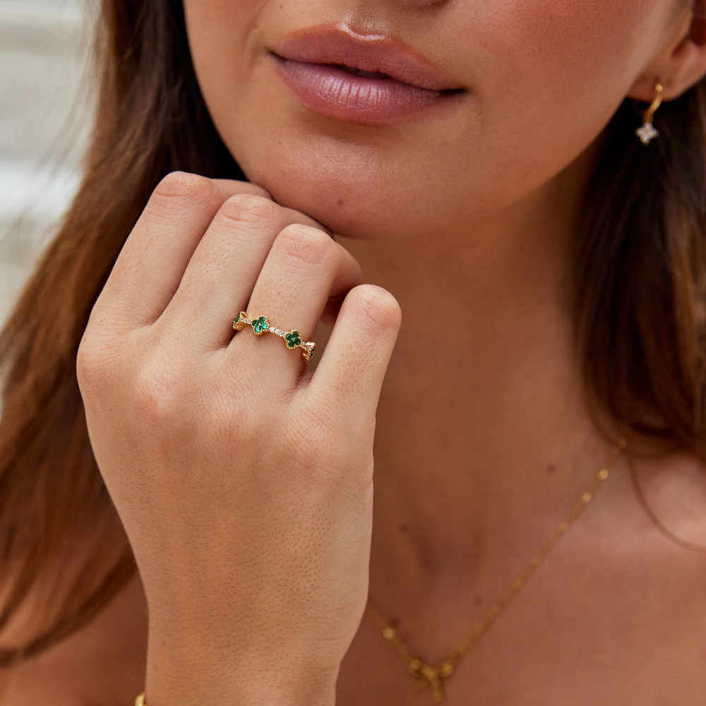 Annika – Zlacený prsten s květinovými detaily a smaragdovým prvkem.