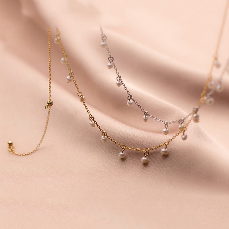 Irma – Kulaté perlové náušnice se strukturovaným zlatým okrajem.