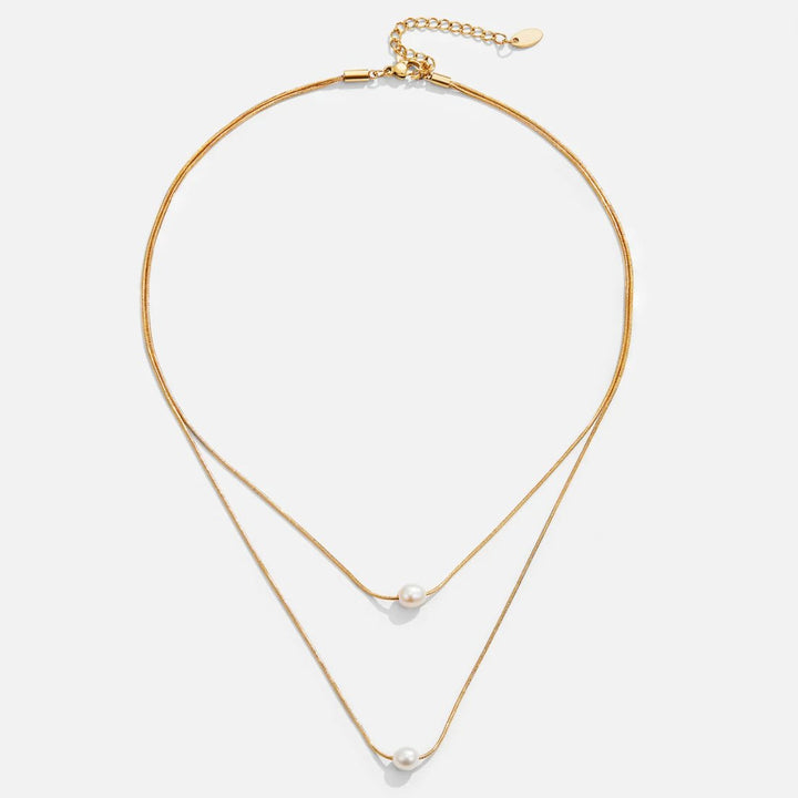 Sabina – Dvouvrstvá zlatá řetěz s tmavým kamenem.