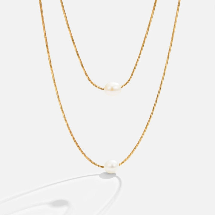 Sabina – Dvouvrstvá zlatá řetěz s tmavým kamenem.