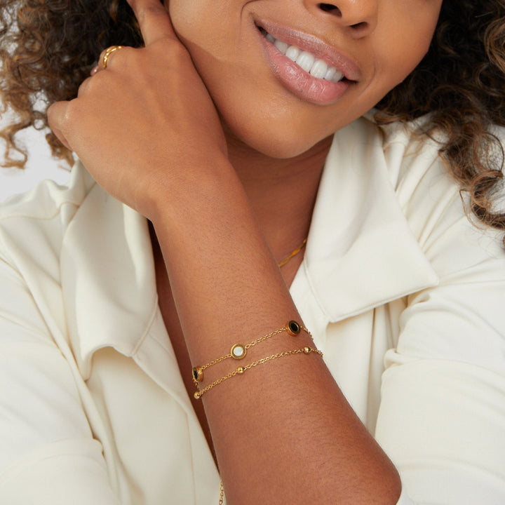 Carla – Jemný zlatý náramek s kontrastními kulatými prvky.